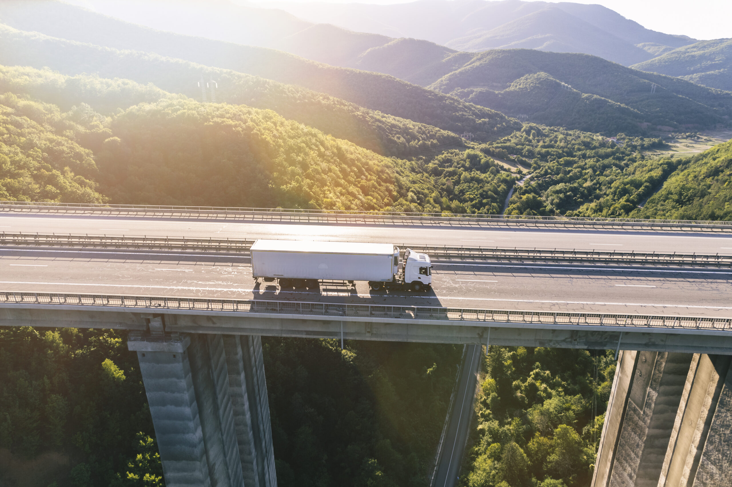 trucks on highway in mountain at sunset trucks on highway in mountain at sunset aerial view